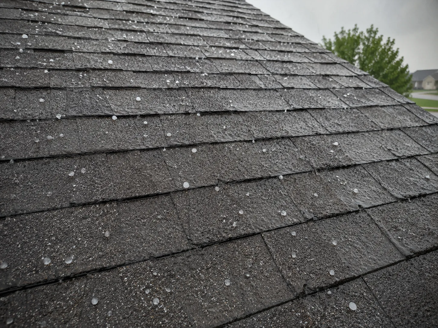 Hailstones on asphalt shingles during a hailstorm