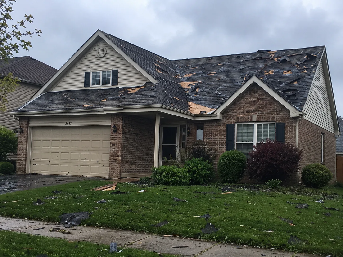 Roof storm damage with missing shingles and exposed roof deck