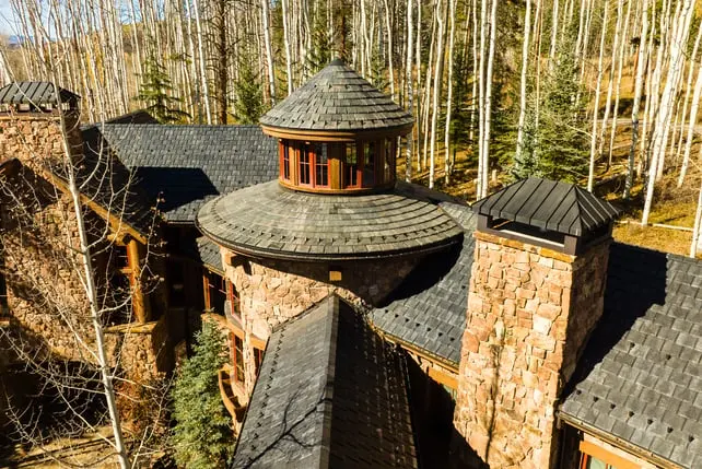 Rustic home with Brava synthetic roof in a wooded setting