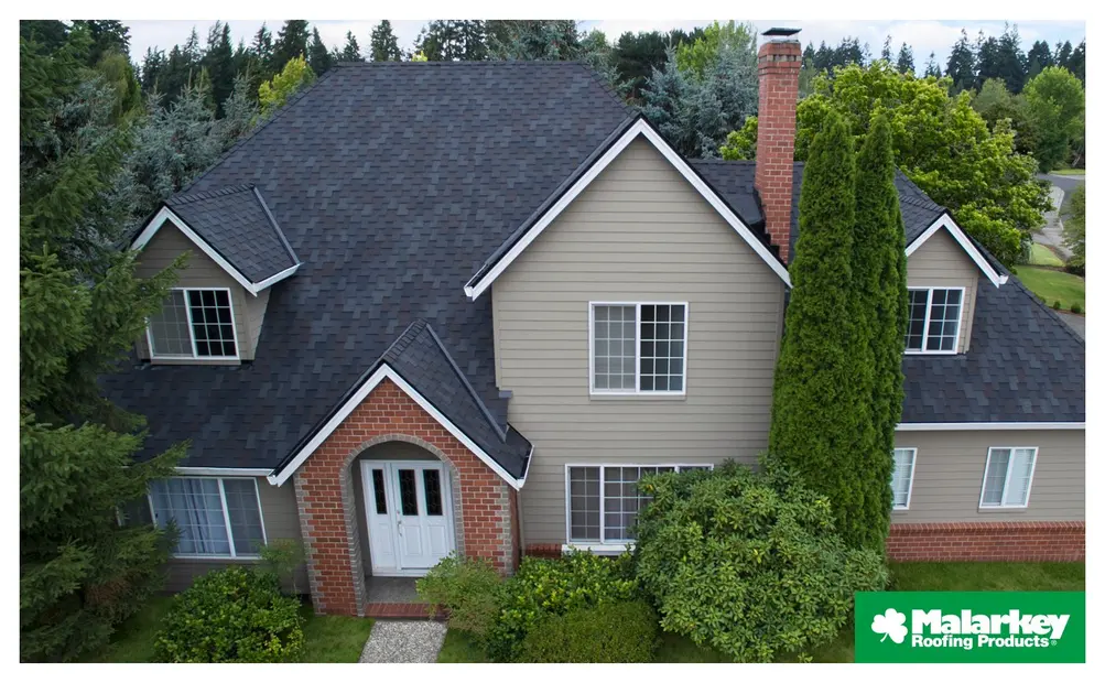 Home with dark Malarkey roofing shingles and landscaping