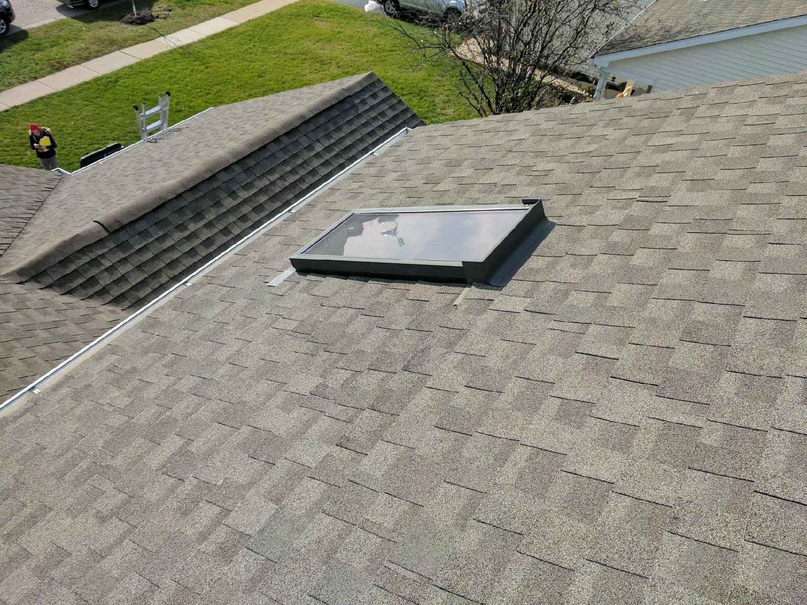 Completed asphalt shingle roof with skylight detail by RG Roofing & Exteriors